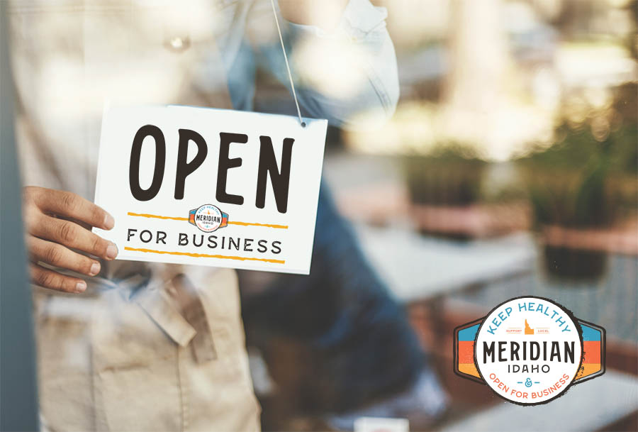 Man placing open sign on cafe door